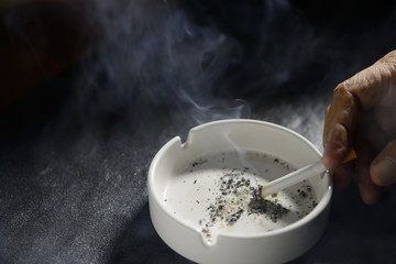 Hand putting the cigarette on an ashtray
