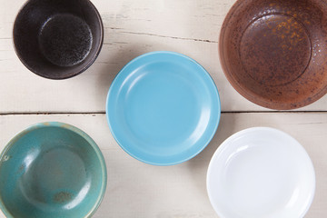 Top view of empty colorful plate put on white wood table.