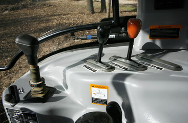 Modern tractor: front loader control joystick, rear attachments controls