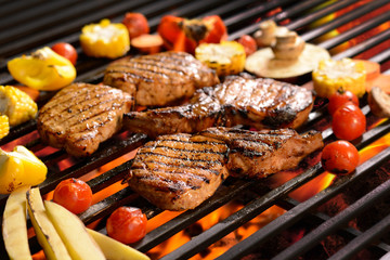 Grilled meat /steak with vegetable on the flaming grill