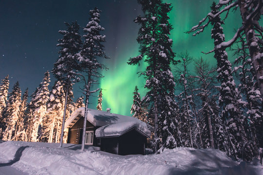 Beautiful picture of massive multicoloured green vibrant Aurora Borealis, Aurora Polaris, also know as Northern Lights in the night sky over winter Lapland, Norway, Scandinavia
