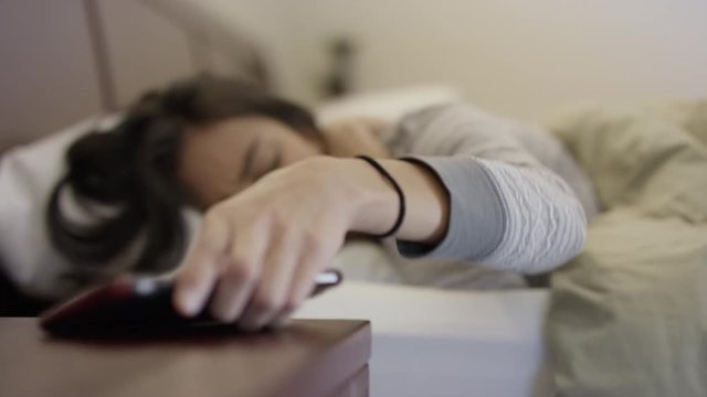Close up of woman in bed waking to alarm / Escalante, Utah, United States