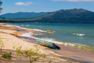 Fototapeta premium Sandy shore of a Baikal with a wooden boat