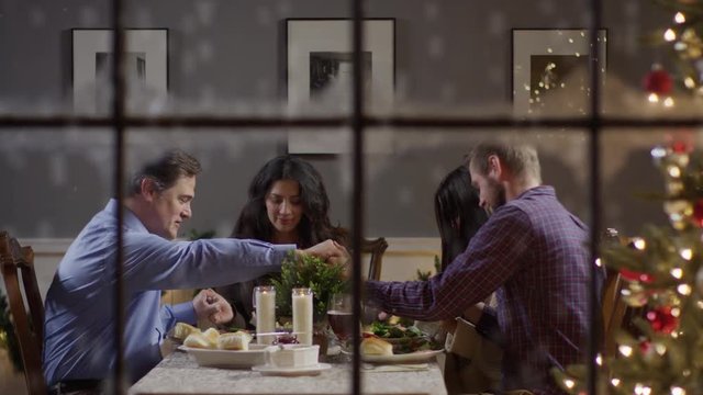 Medium zoom in shot of family saying grace at Christmas meal / Cedar Hills, Utah, United States