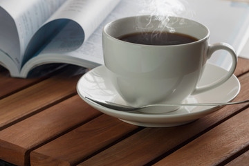 Coffee espresso cup hot with book on a wooden table
