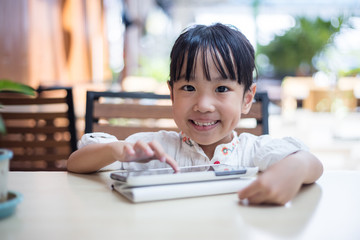 Asian Chinese little girl playing tablet computer
