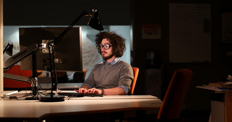 Fototapeta na wymiar man working on computer in dark office