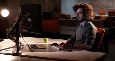 man working on computer in dark office