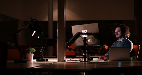 man working on computer in dark office
