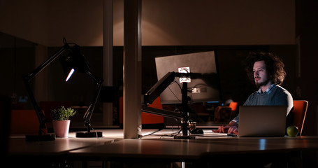 man working on computer in dark office