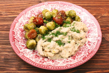 Tasty chicken meat under creamy sauce with brussels sprouts garn