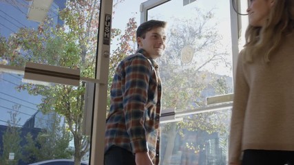 Medium to close up panning shot of man opening door for woman / Provo, Utah, United States