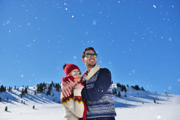 Happy couple playful together during winter holidays vacation outside in snow park