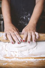 Obraz na płótnie Canvas Woman rolling dough with rolling pin.