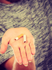 Closeup of broken cigarette on male hand.