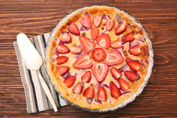 Tart with fresh strawberry on wooden background