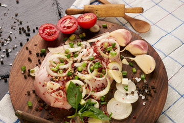 Fresh chicken fillet with fresh vegetables mushrooms onion rosemary and seasoning spices on dark wooden board. Culinary cooking ingredients. Helthy diet food.