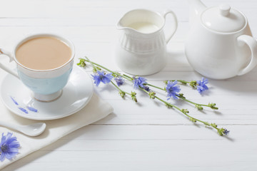 Drink from chicory in a cup on the white wooden table