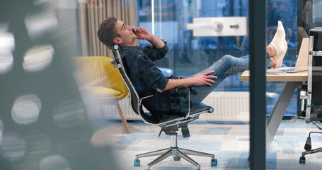 businessman sitting with legs on desk