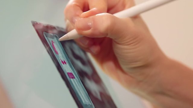 Woman's hand drawing on tablet