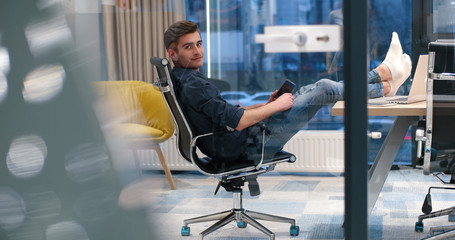 businessman sitting with legs on desk