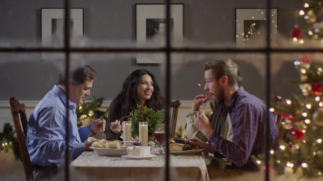 Medium zoom out shot of couples eating meal at table on Christmas / Cedar Hills, Utah, United States