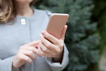 Woman on the street holding a pink phone