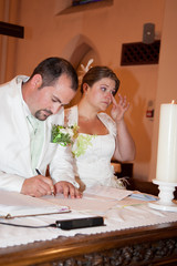 Bride and Groom signing the register after the ceremony