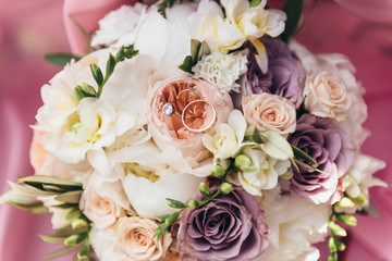 Fototapeta na wymiar Wedding rings lie on a bouquet of fresh flowers