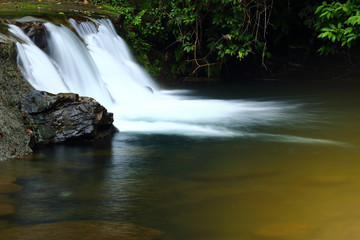 Small Waterfall in shallow river in deep forest jungle,