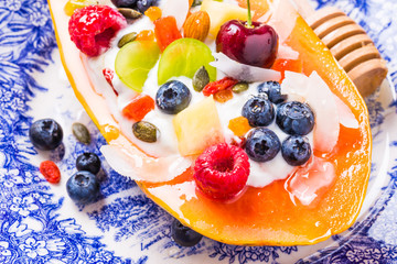 Fruit salad bowl with fruits, berries, nuts.