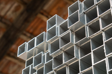 Square box aluminum profiles stacked in the warehouse - obrazy, fototapety, plakaty