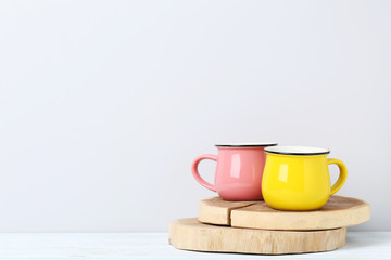 Pink and yellow mug on white wooden table
