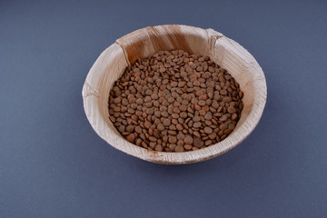 Lentils and spoon in a wooden bowl.