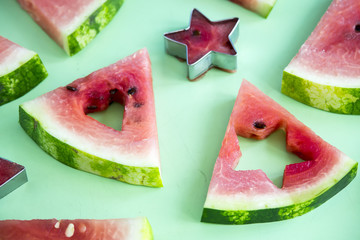 Watermelon slices and carved shape shapes on a green background