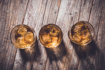 Whiskey glasses on an old wooden table. Close up