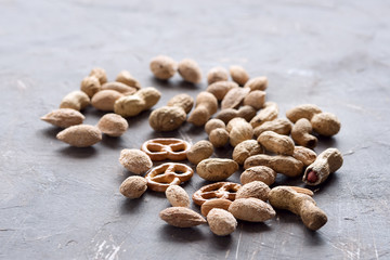 Fototapeta na wymiar Nuts Unpeeled almonds peanuts and tasty crackers lying on background Copy space