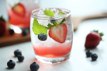 Strawberry juice cocktail with ice and mint on white tone amd wooden