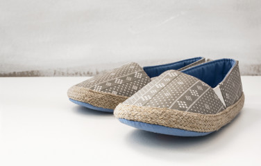 Toddler shoes. Stylish pair of espadrilles over white painted background