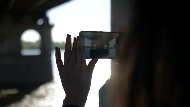 Make a beautiful photo on the phone under the bridge on the river. SLOW MOTION. HD, 1920x1080.