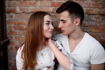 Naklejka premium Portrait of young modern couple in love, posing outdoors in city street