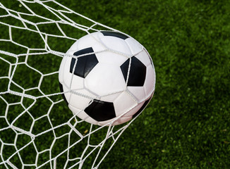 Plakat Soccer football in Goal net with green grass field.