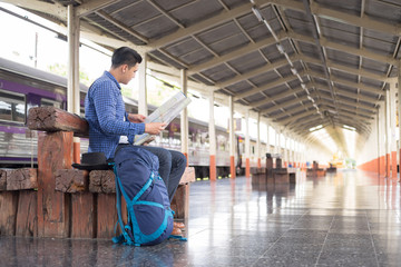 Fototapeta premium man traveler with backpacker look searching location map at trainstation