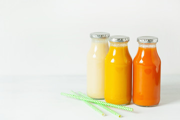 fruit and vegetable smoothies in glass jars, orange mango banana carrot pineapple