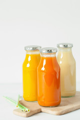 fruit and vegetable smoothies in glass jars, orange mango banana carrot pineapple