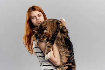 Young beautiful woman on white isolated background holds a cat