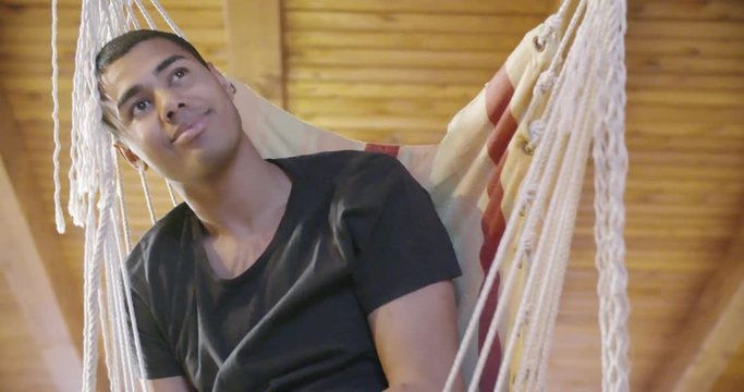 black man on hammock relaxing.indoor in modern industrial house. 4k handheld slow motion video shot