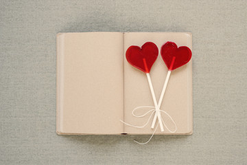 Two heart-shaped lollipops on an old diary