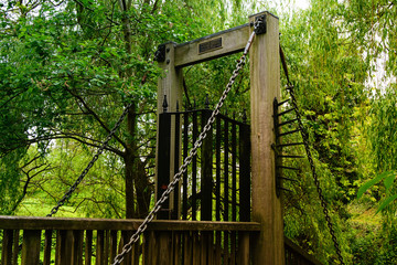 Old wooden bridge with iron gate in park