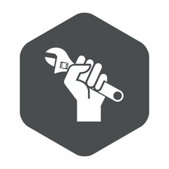 Icono plano mano con llave inglesa en hexagono gris